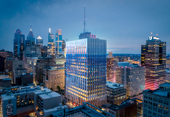 A rendering of the Philadelphia skyline at night depicts the Honickman Center building with a Jefferson Health logo on it.
