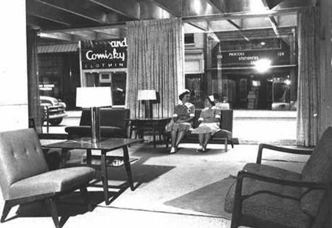 Section of one of the first floor lobbies in the new hospital pavilion. Two nurses are seated on a couch.