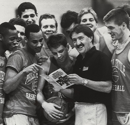 Coach Herb Magee stands with the basketball team.