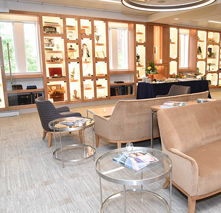 The interior of the Pinizzotto-Ammon Alumni Center with a seating area featuring several couches, chairs and tables for visitors.