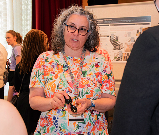  Professor Kim Mollo speaks with attendees during the Design Assistive Device Project presentation.