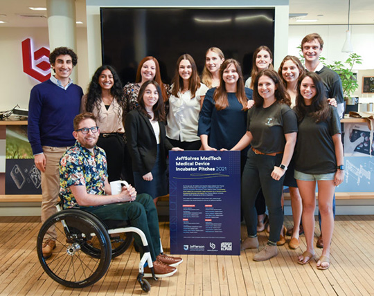 A group of Health Design Lab participants pose with members of the Bressler Group, a design firm that specializes in medical devices, during a public prototype pitch event.