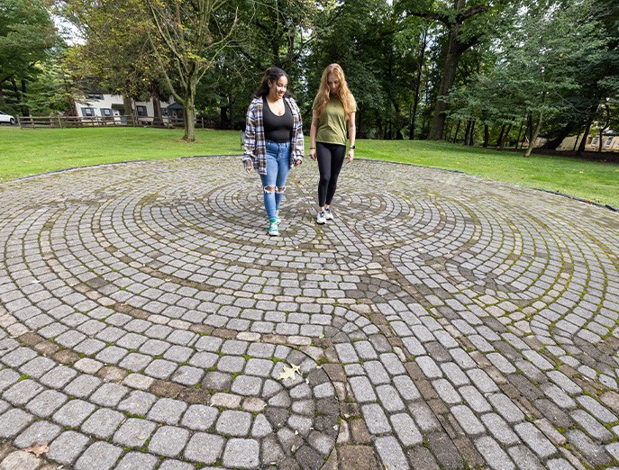 Two students walk across the September 11 Memorial Labyrinth on Jefferson’s East Falls Campus.