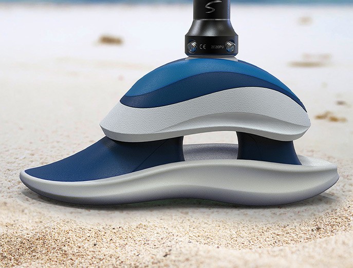 A close-up of the Swell Surf Foot prosthetic, which features a blue and white exterior design in two layers with a cutout in the center.